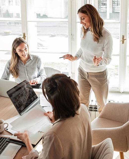 hm-about-us-01 Women looking at laptop around table
